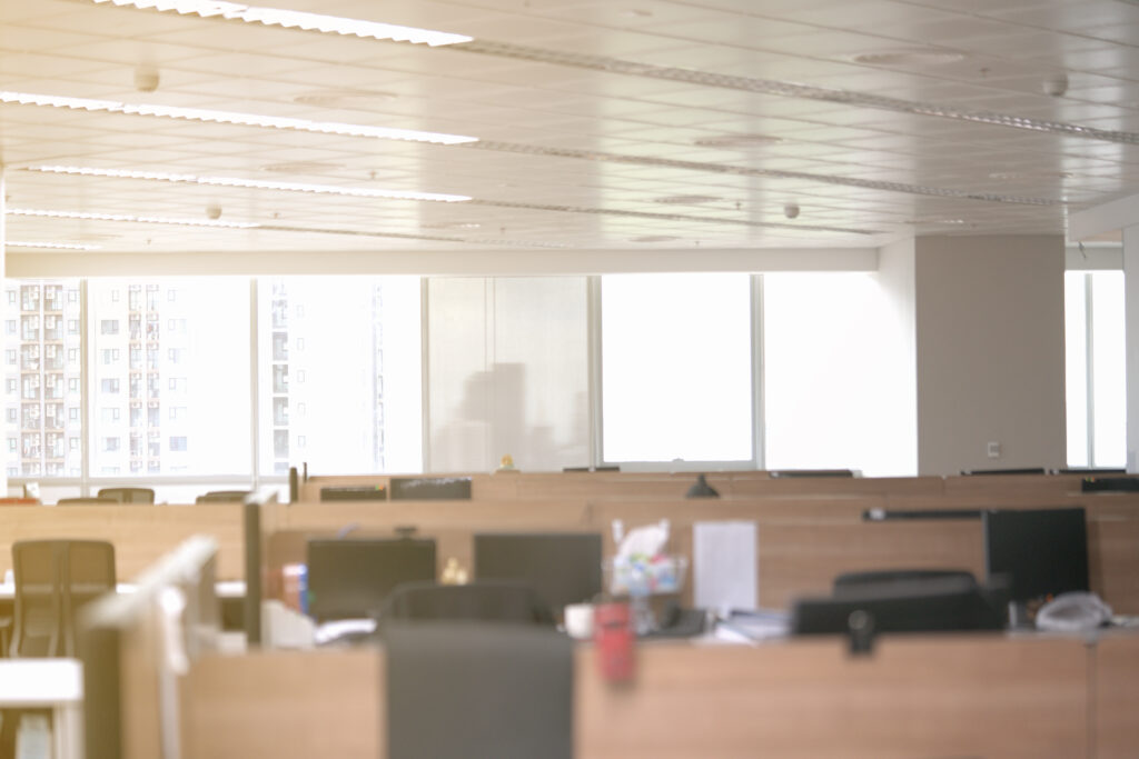 Modern open-plan commercial office with cubicles and bright windows before renovation or tenant improvement upgrades.
